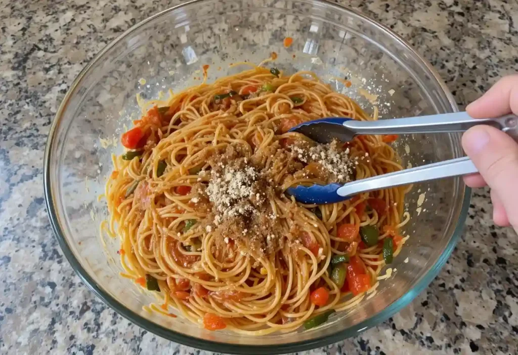 Spaghetti, veggies, and sauce mixed in a large bowl.